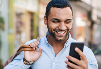 Man holding cell phone and smiling