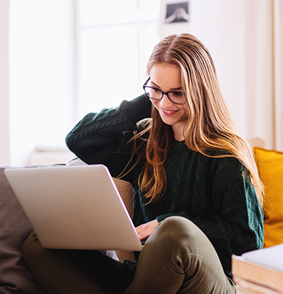 Woman sitting in front of laptop while typing
