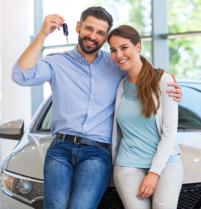 Two people leaning on hood of car holding keys