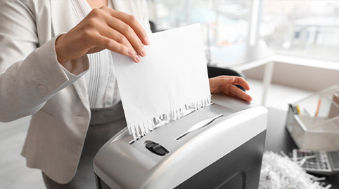 Woman shredding paper in paper shredder