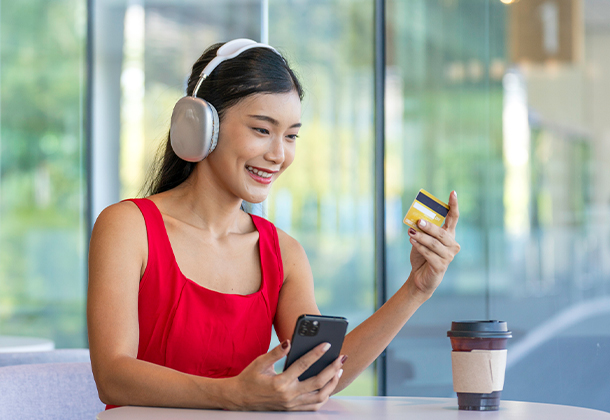 person holding phone and looking at credit card