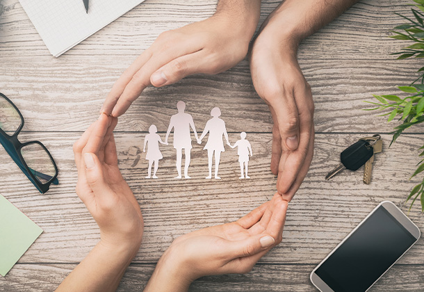 Hands in circle around cutouts of a family of four