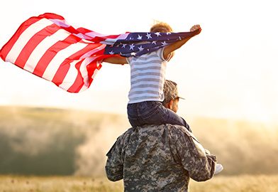 Child with American Flag on a Soldier's shoulders