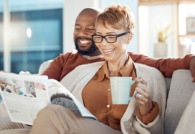Happy couple reading a newspaper